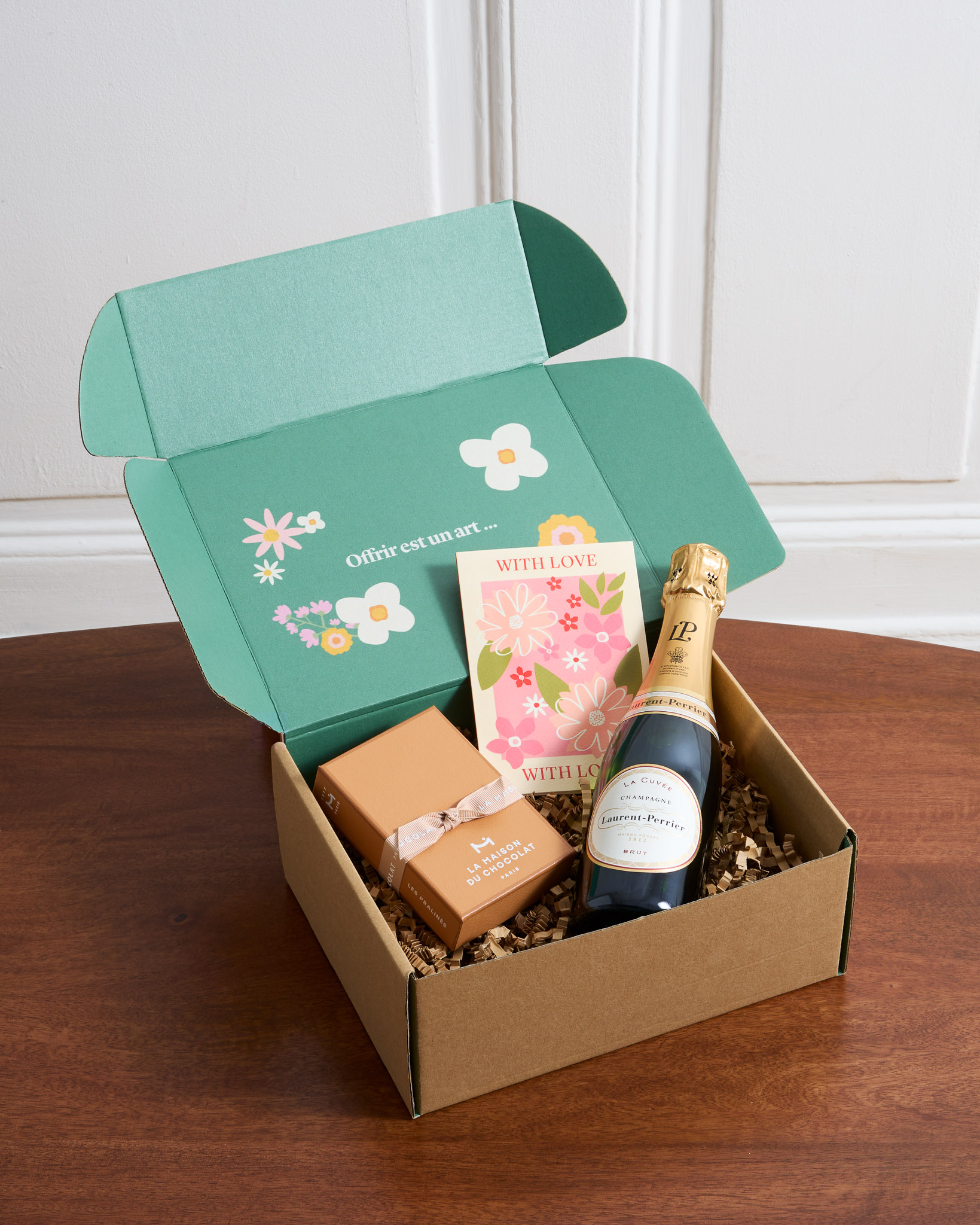 Ce coffret contient : une bouteille de Champagne Laurent-Perrier de 37.5cl, un coffret de chocolats pralinés Maison du Chocolat et une carte illustrée